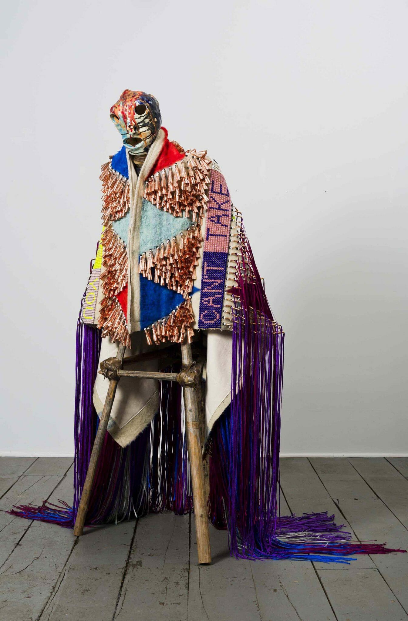 Jeffrey Gibson (Mississippi Band Choctaw/Cherokee), CAN'T TAKE MY EYES OFF OF YOU, 2015. High fire glazed ceramic, repurposed tipi poles, wool, acrylic paint, wool blanket, glass beads, artificial sinew, copper jingles, and nylon fringe; 72 × 29 × 38 in. Collection of Vicki and Kent Logan. Image courtesy of Jeffrey Gibson Studio and Roberts Projects, Los Angeles, California. Photograph by Peter Mauney.