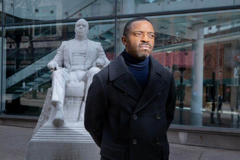 Artist Faisal Abdu'Allah standing in front of his counter-monument modeled after him