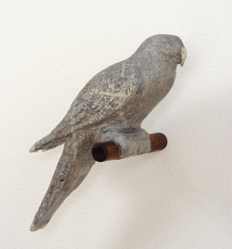 bird sculpture made of beeswax and cherry wood, attached to a wall