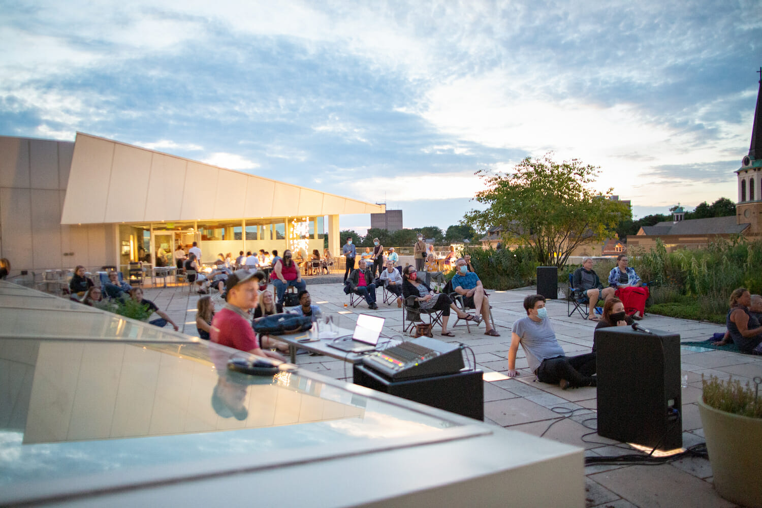 People seated in the Rooftop Sculpture Garden watching an outdoor film screening during MMoCA Rooftop Cinema