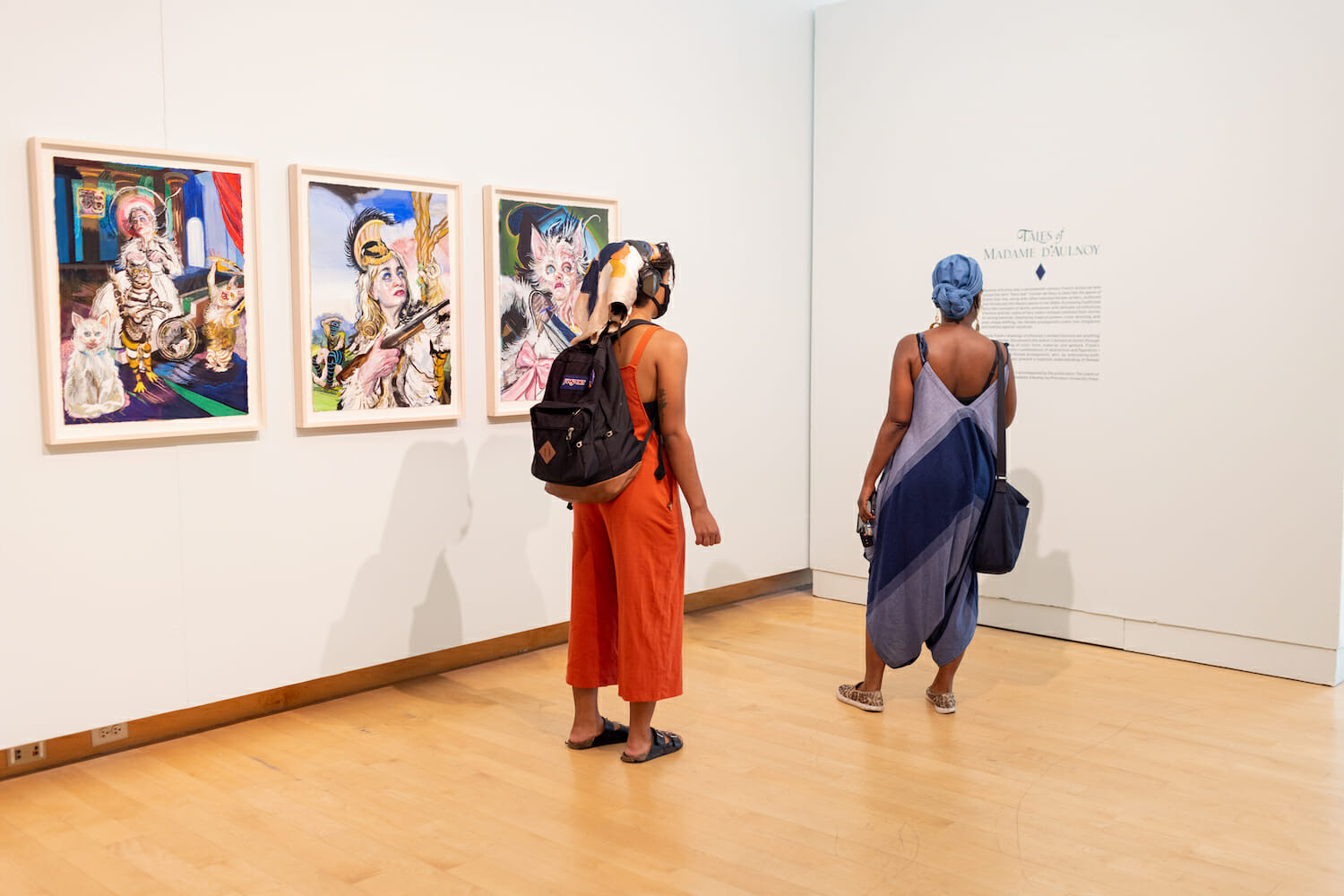 two people looking at artwork hanging on the wall