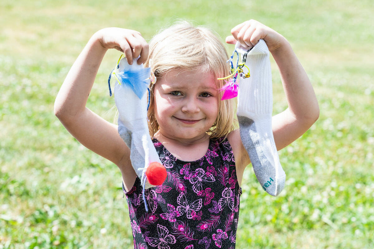 child holding up two decorated socks