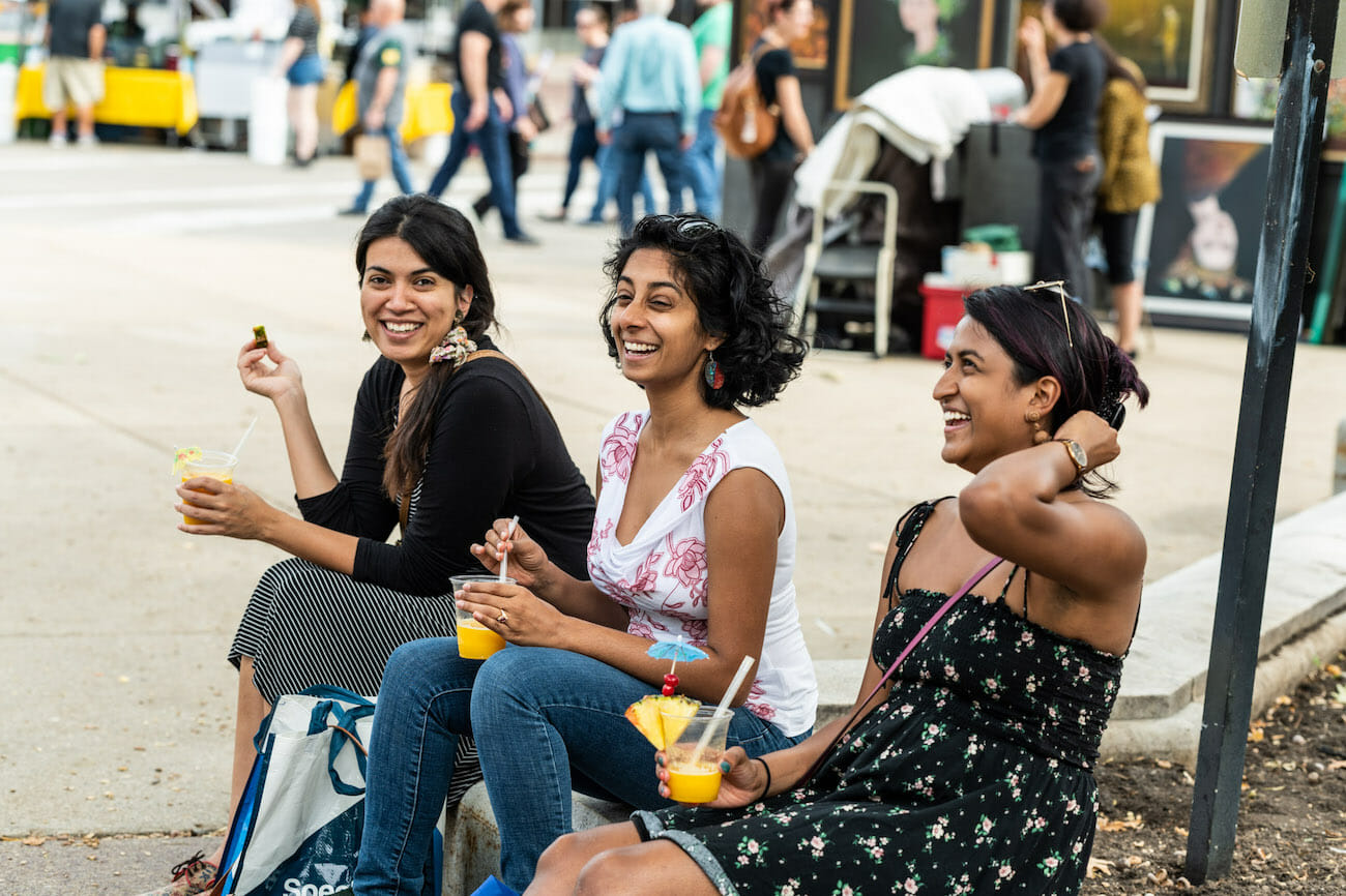 Three visitors seated at Art Fair on the Square