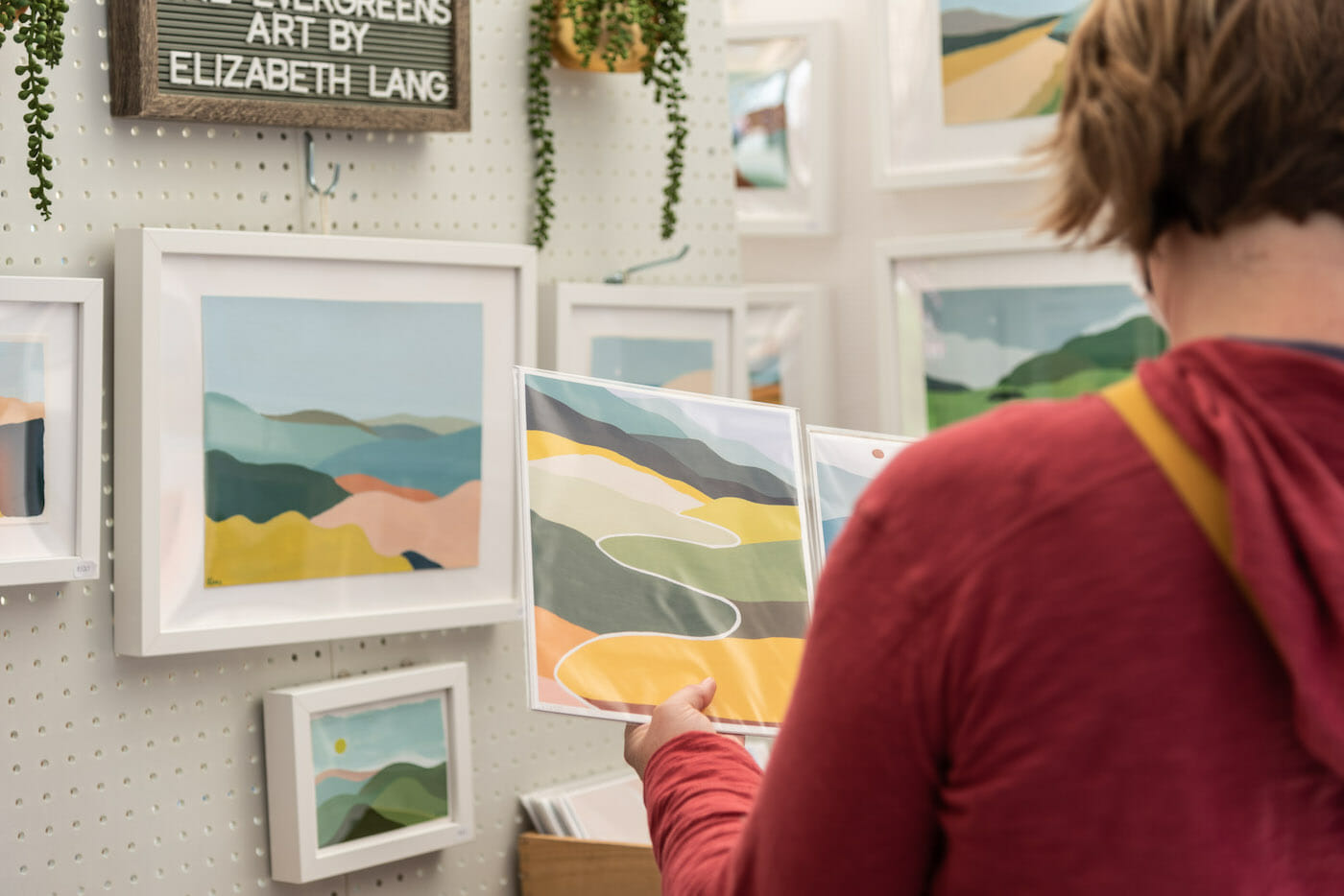 Visitor holding artwork prints