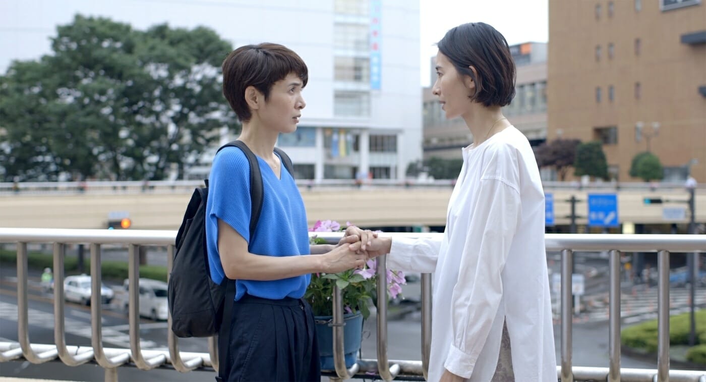 film still showing two people holding hands