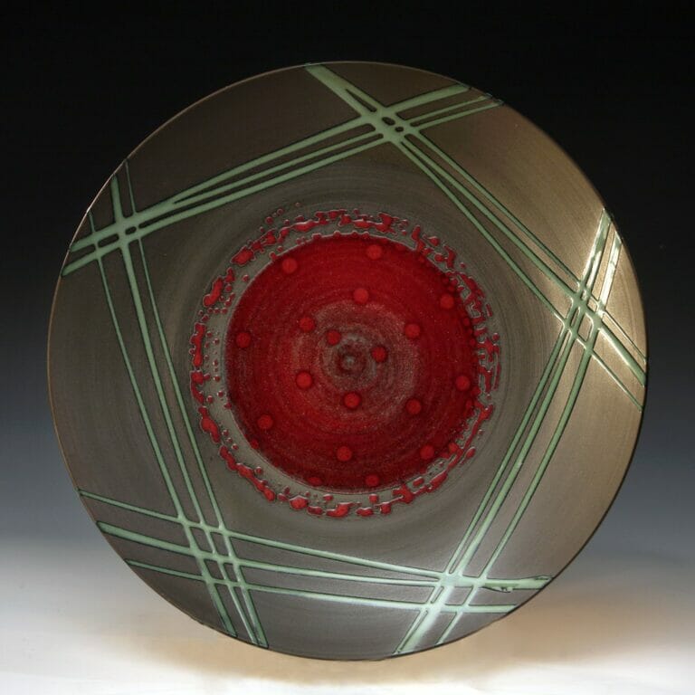 ceramic vase with abstract splatter-like shapes forming a circle around the center of the plate, and lines forming a pentagon