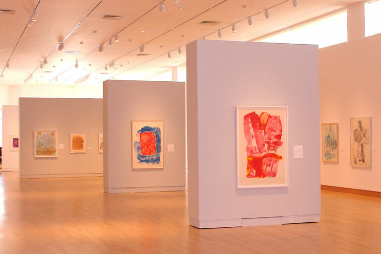 installation view of "Signs of the Times: Robert Rauschenberg's America" featuring artworks hanging on the wall