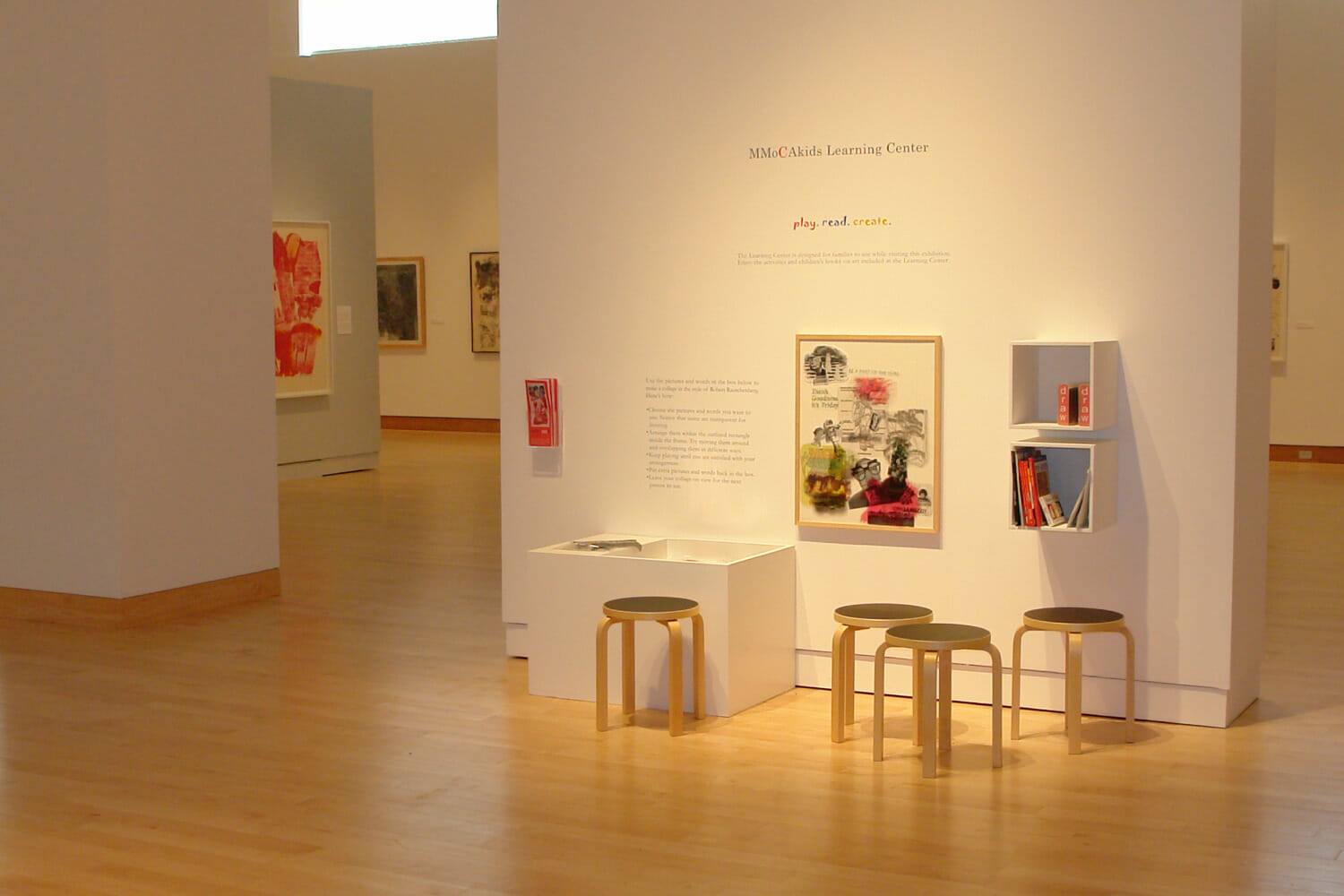 installation view of "Signs of the Times: Robert Rauschenberg's America" featuring a children's learning center and artworks hanging on the wall