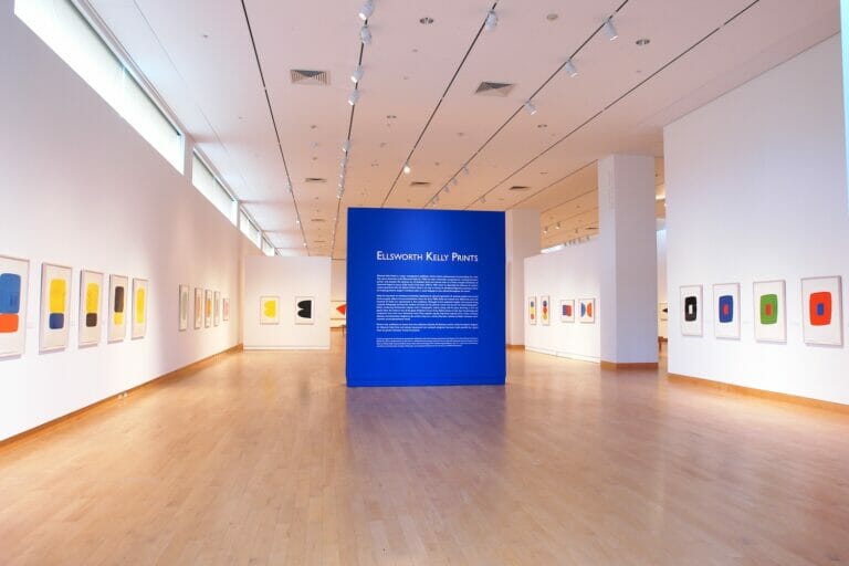 installation view of an exhibition with a wall with title text that reads "Ellsworth Kelly Prints"