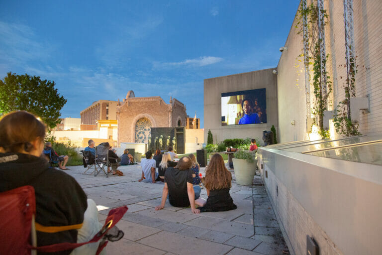 people seated on the Rooftop Sculpture Garden enjoying an outdoor film screening