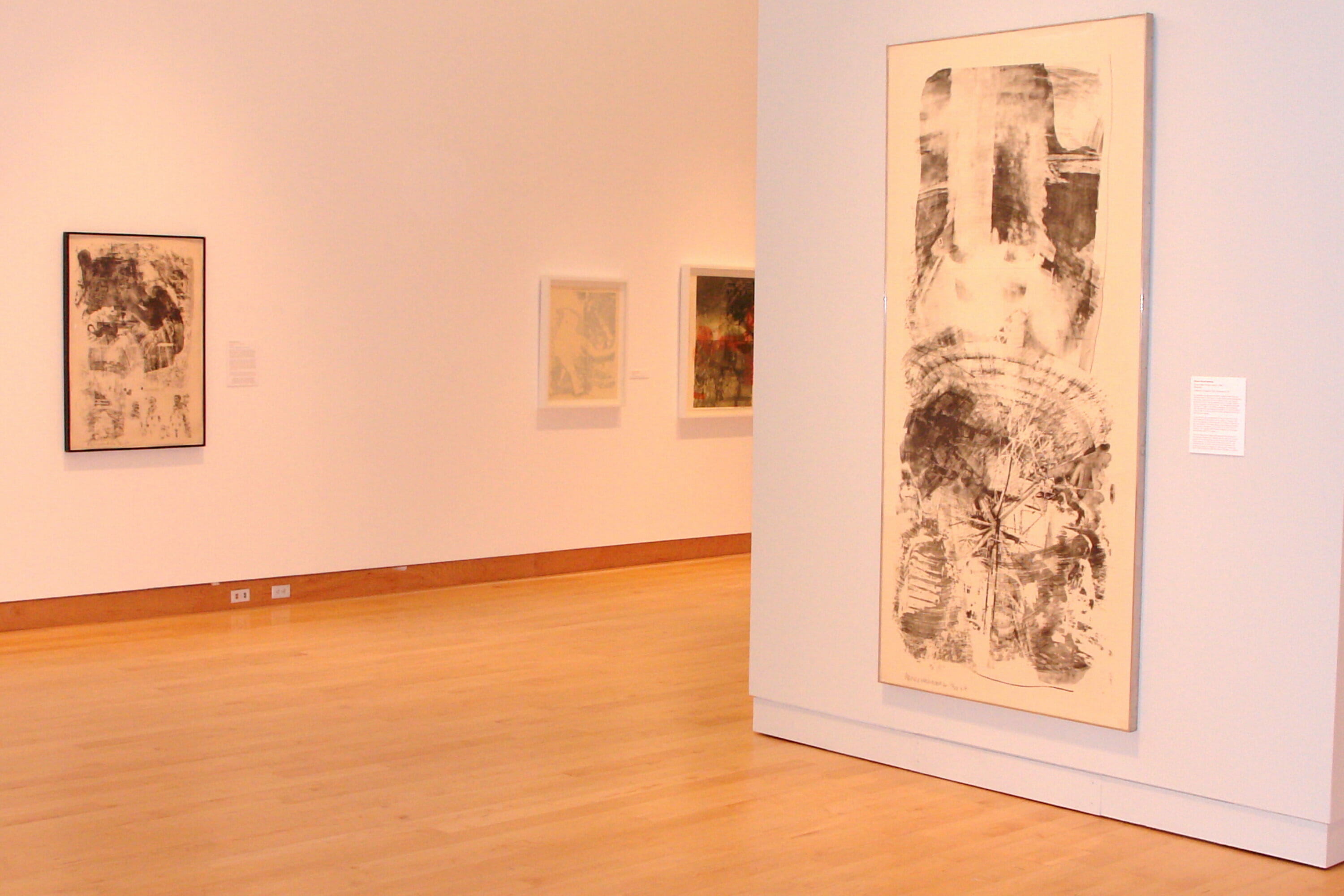 installation view of "Signs of the Times: Robert Rauschenberg's America" featuring artworks hanging on the wall