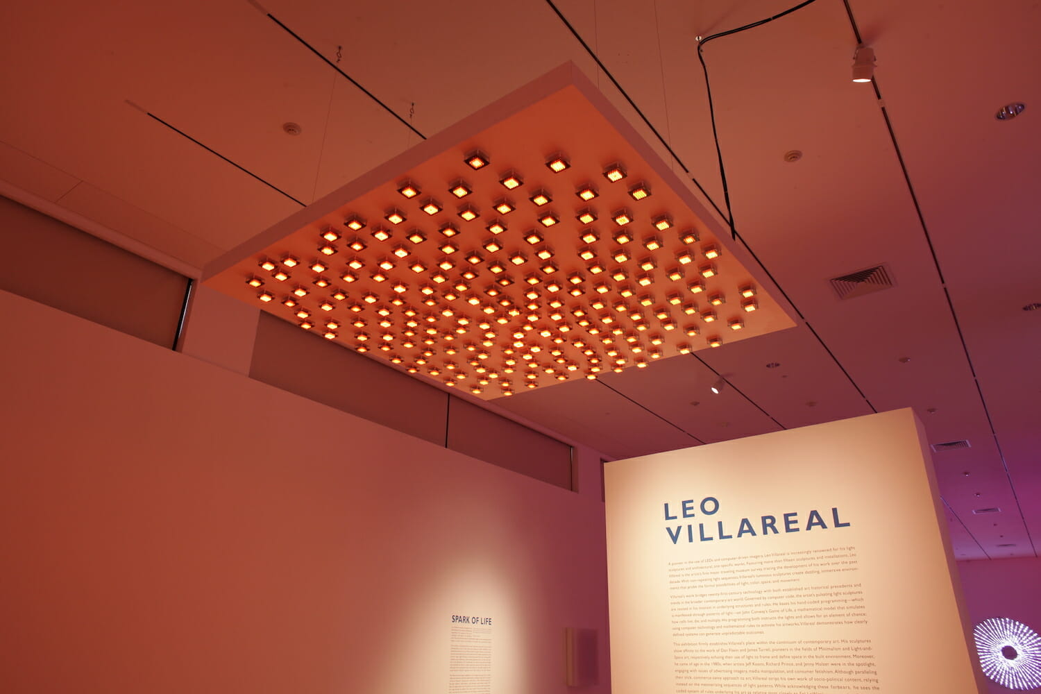 installation view of "Leo Villareal" showing title wall text and a light artwork hanging from the ceiling