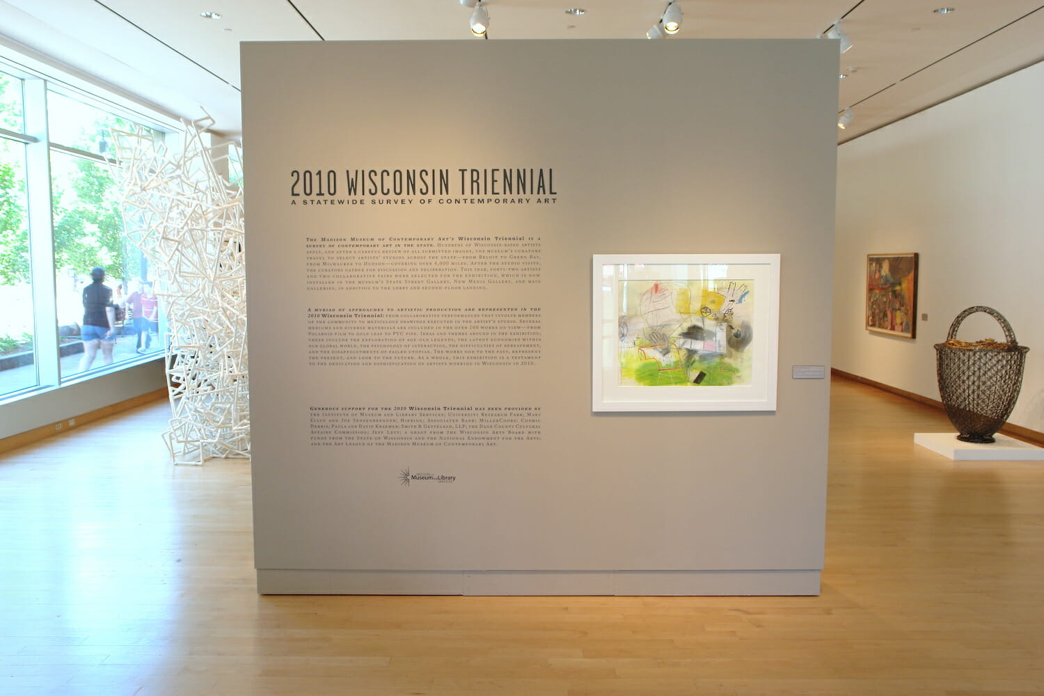 installation view of the 2010 Wisconsin Triennial featuring a framed artwork next to title wall text