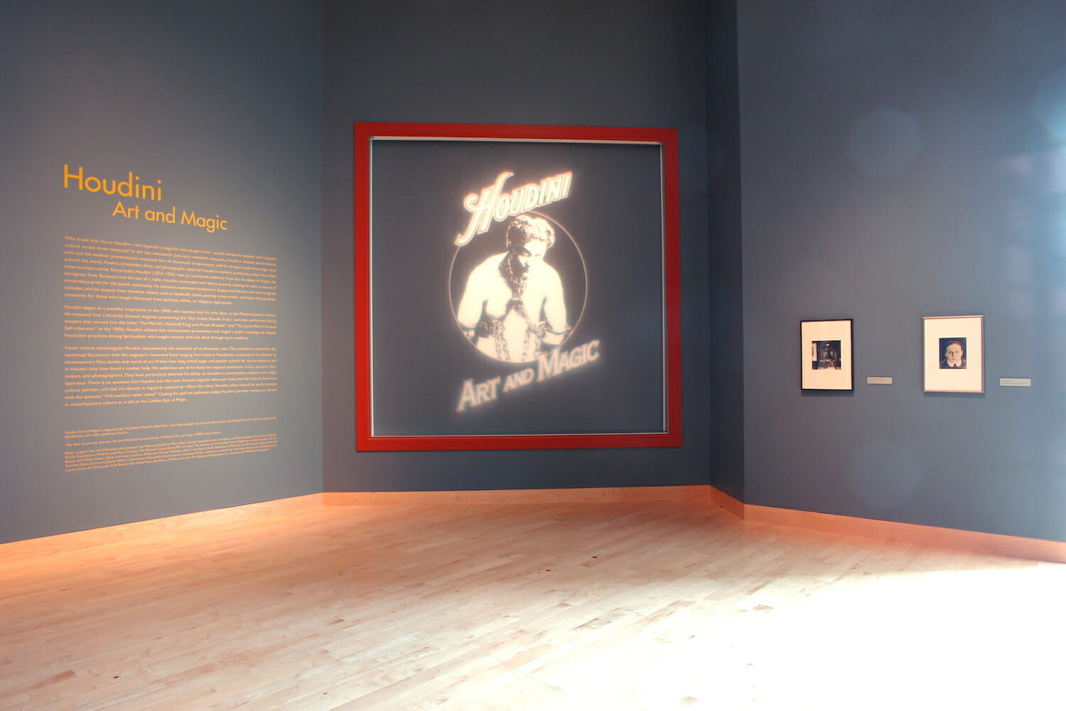 installation view of Houdini: Art and Magic featuring framed artworks hanging on walls and title wall text