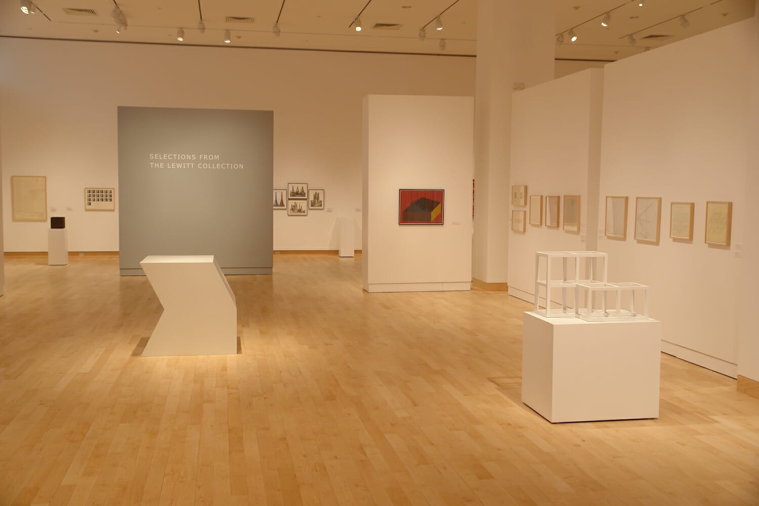 installation view of the Sol LeWitt exhibition showing various geometric sculptures or structures and artwork displayed on walls