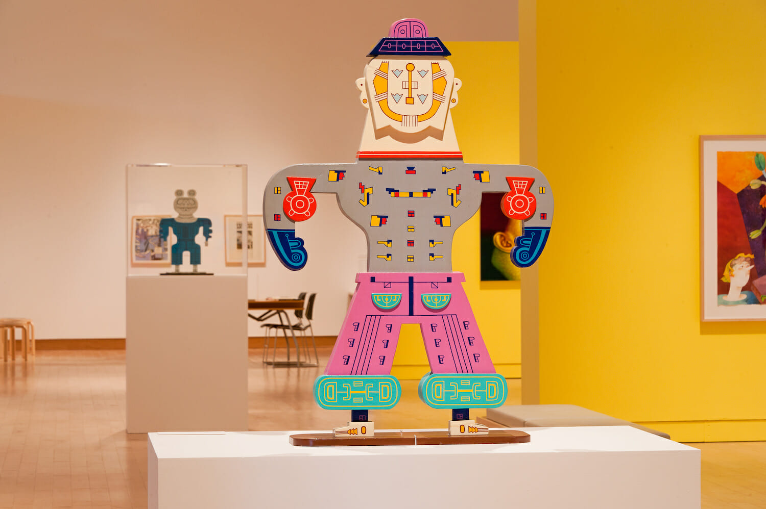 installation view of the exhibition Chicago Imagists featuring a close up of a paper doll-like wooden cutout of a person, painted in a cartoonish style