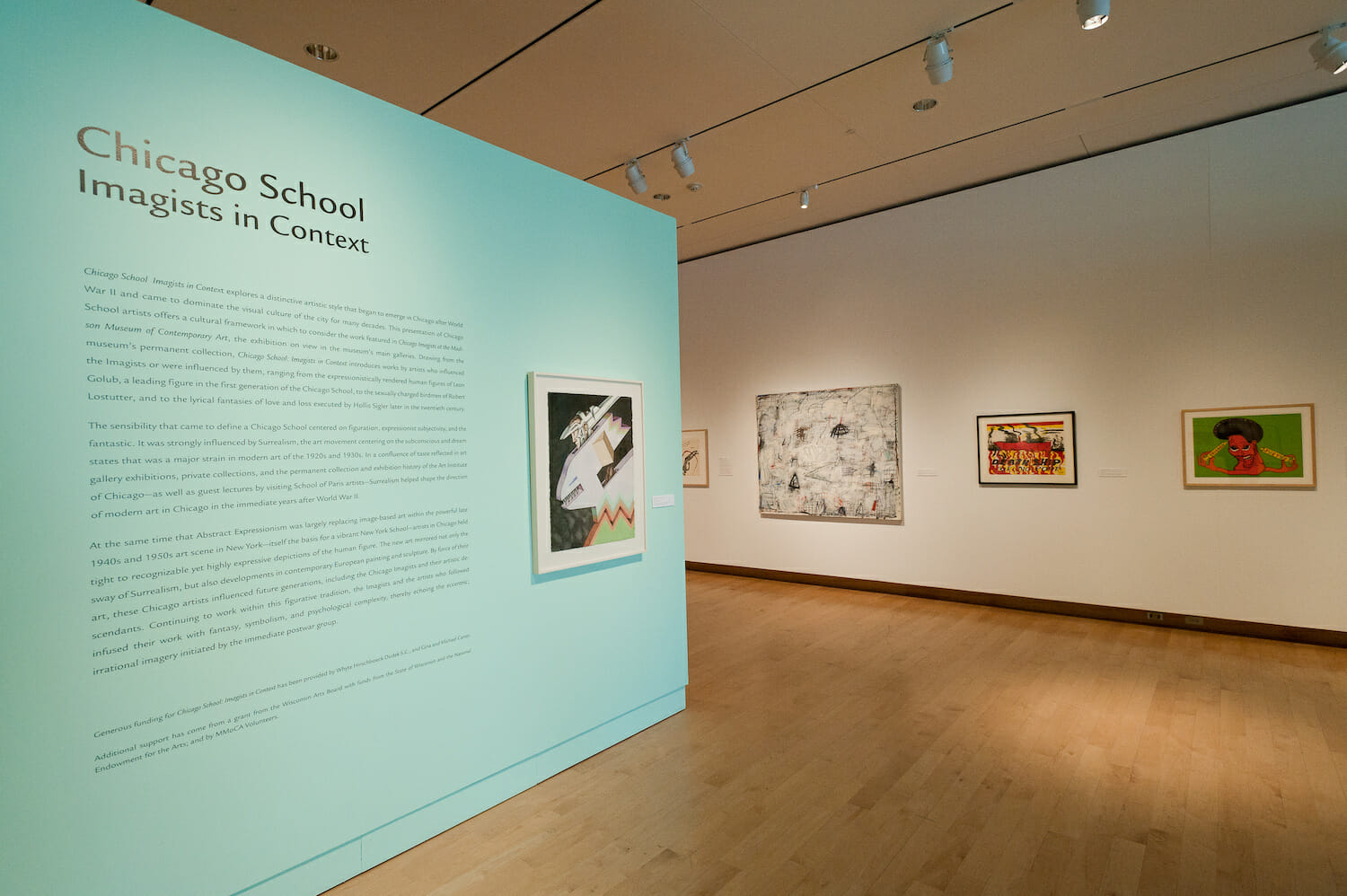 installation view of the exhibition Chicago School featuring title wall text and framed artworks hanging vertically across walls