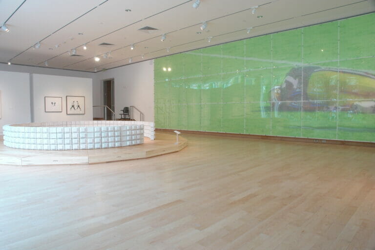 gallery installation view of Tim Laun: Sunday, September 20th, 1992, featuring a large plaster model on the ground and a laminated panel depicting a football or baseball player on the ground