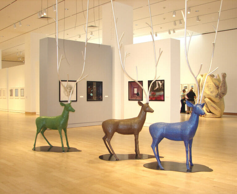 installation view of the 2007 Wisconsin Triennial, featuring three reindeer sculptures with extremely tall antlers