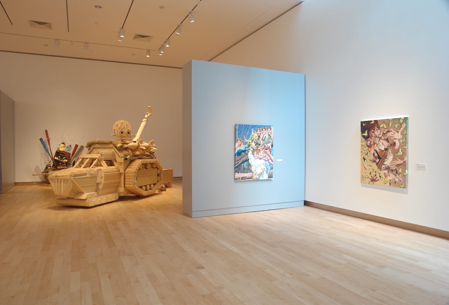 installation view of the 2007 Wisconsin Triennial, featuring a large sculpture resembling a tank as well as paintings or artworks hanging on walls