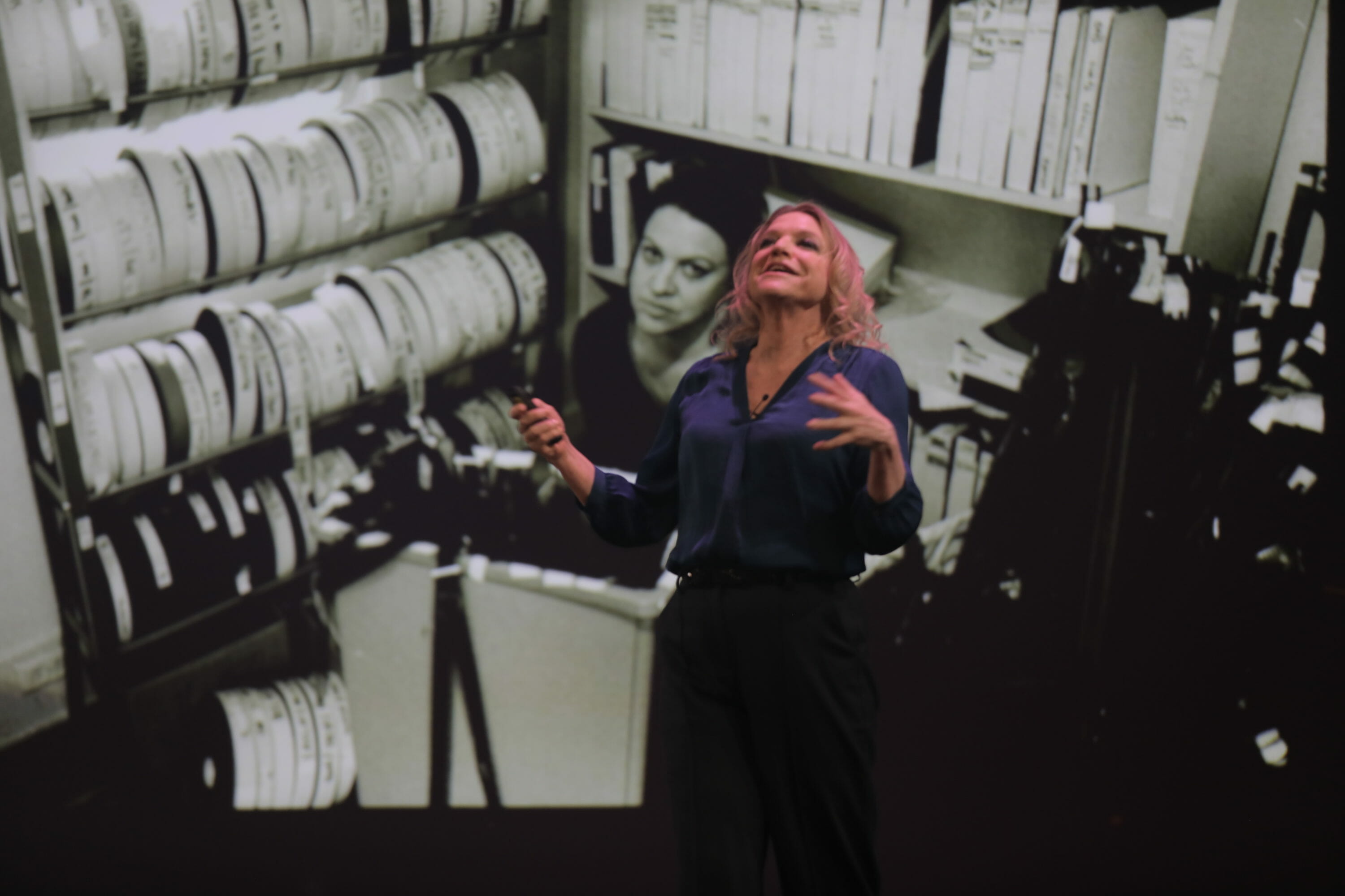 woman speaking in front of an image