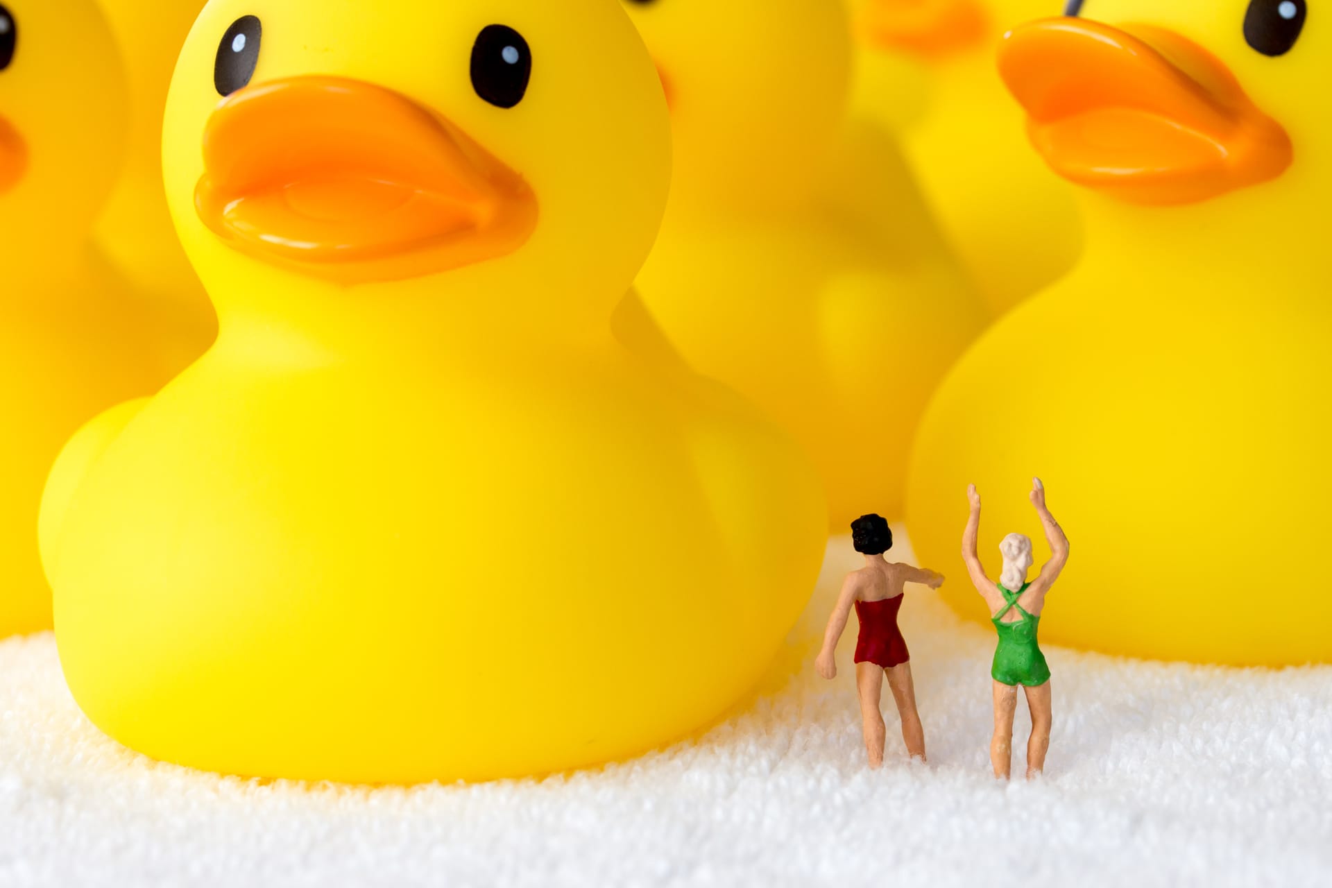 small figures surrounded by large rubber ducks