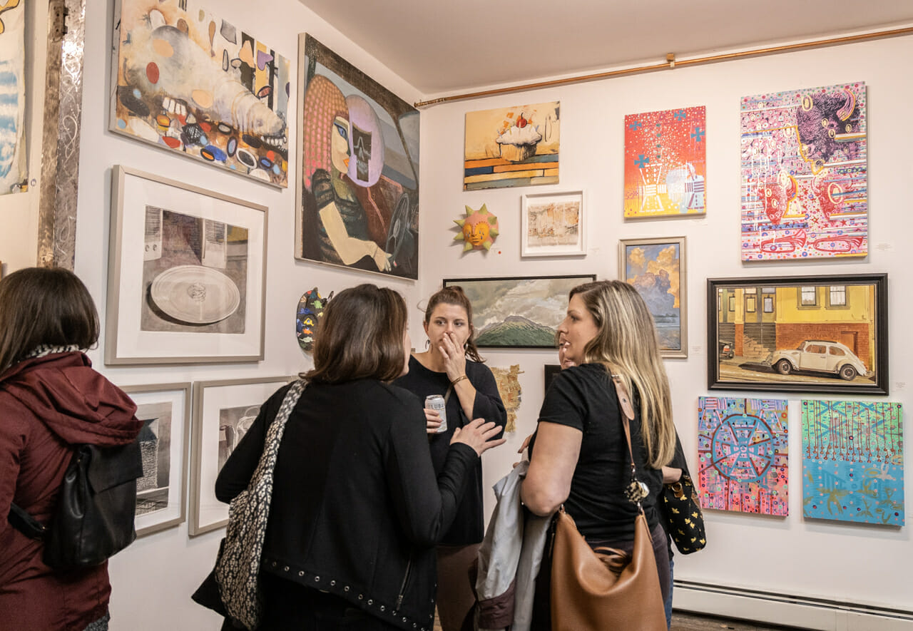 A group of people standing in a gallery.