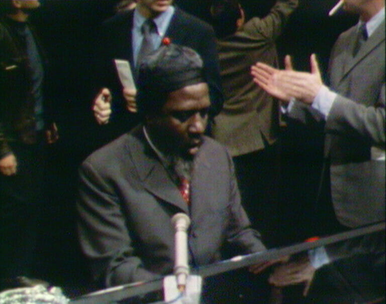 Film still from Rewind and Play showing Thelonious Monk playing the piano.