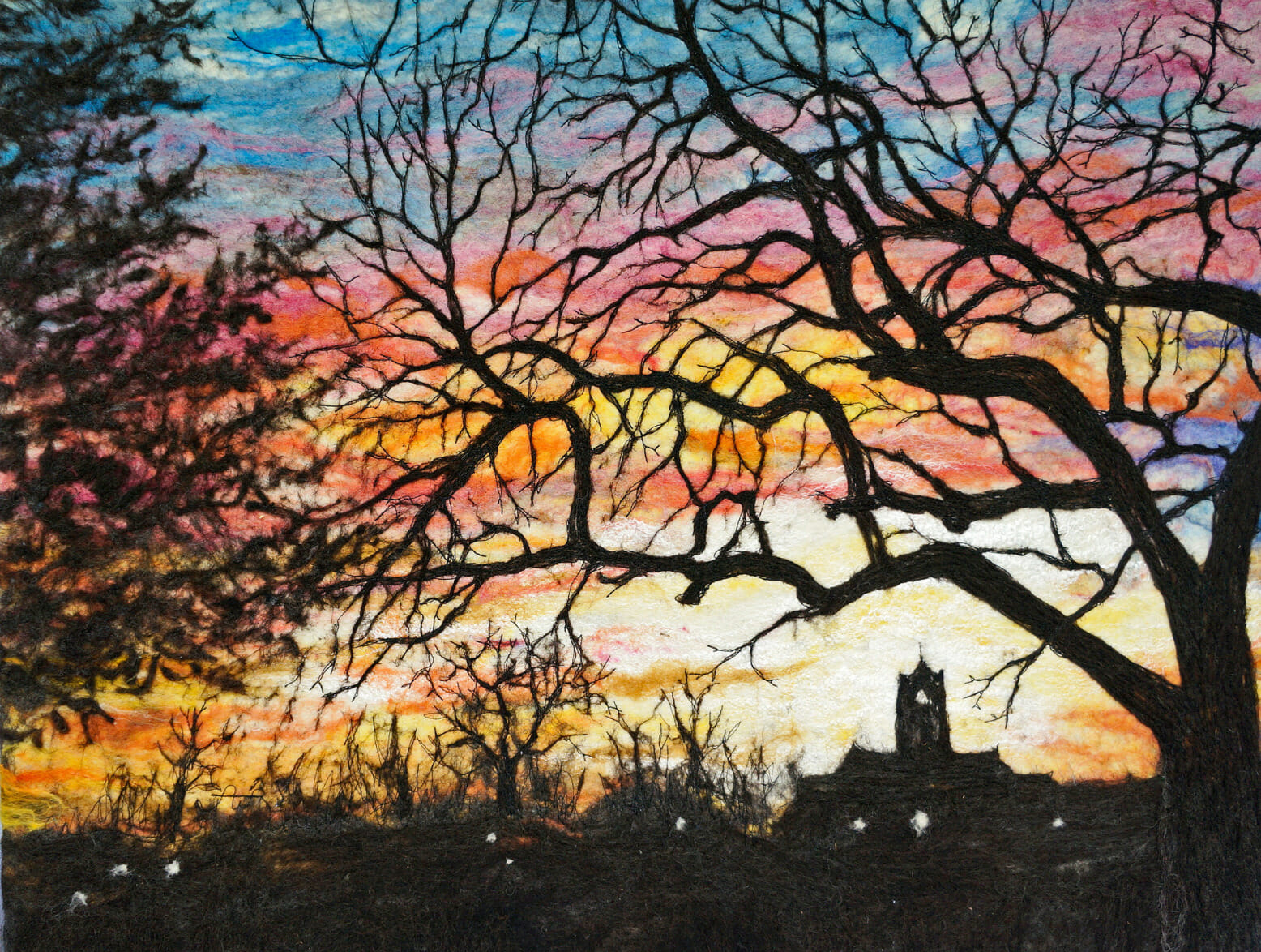 Fiber wool art depicting trees against a sunset sky.