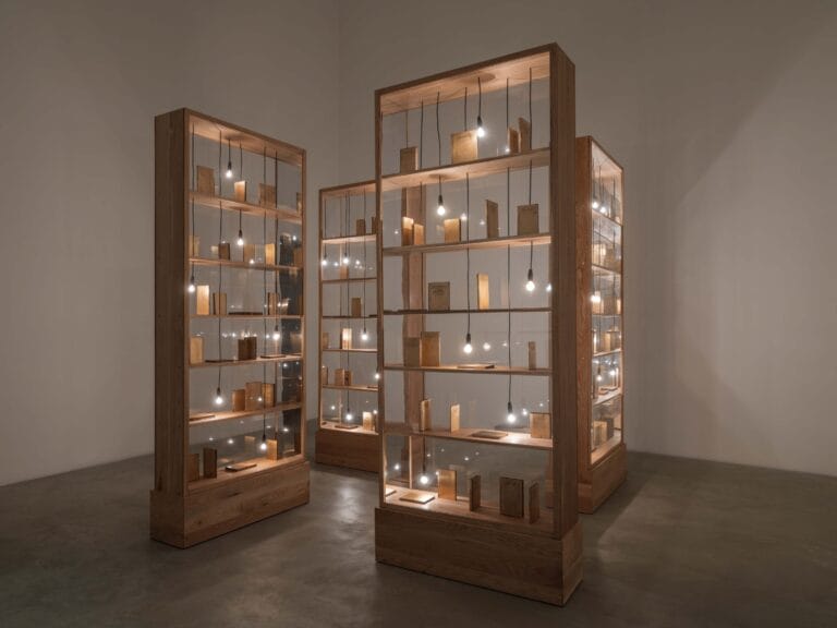 Image of artwork made of gun metal, wood, glass, and light bulbs