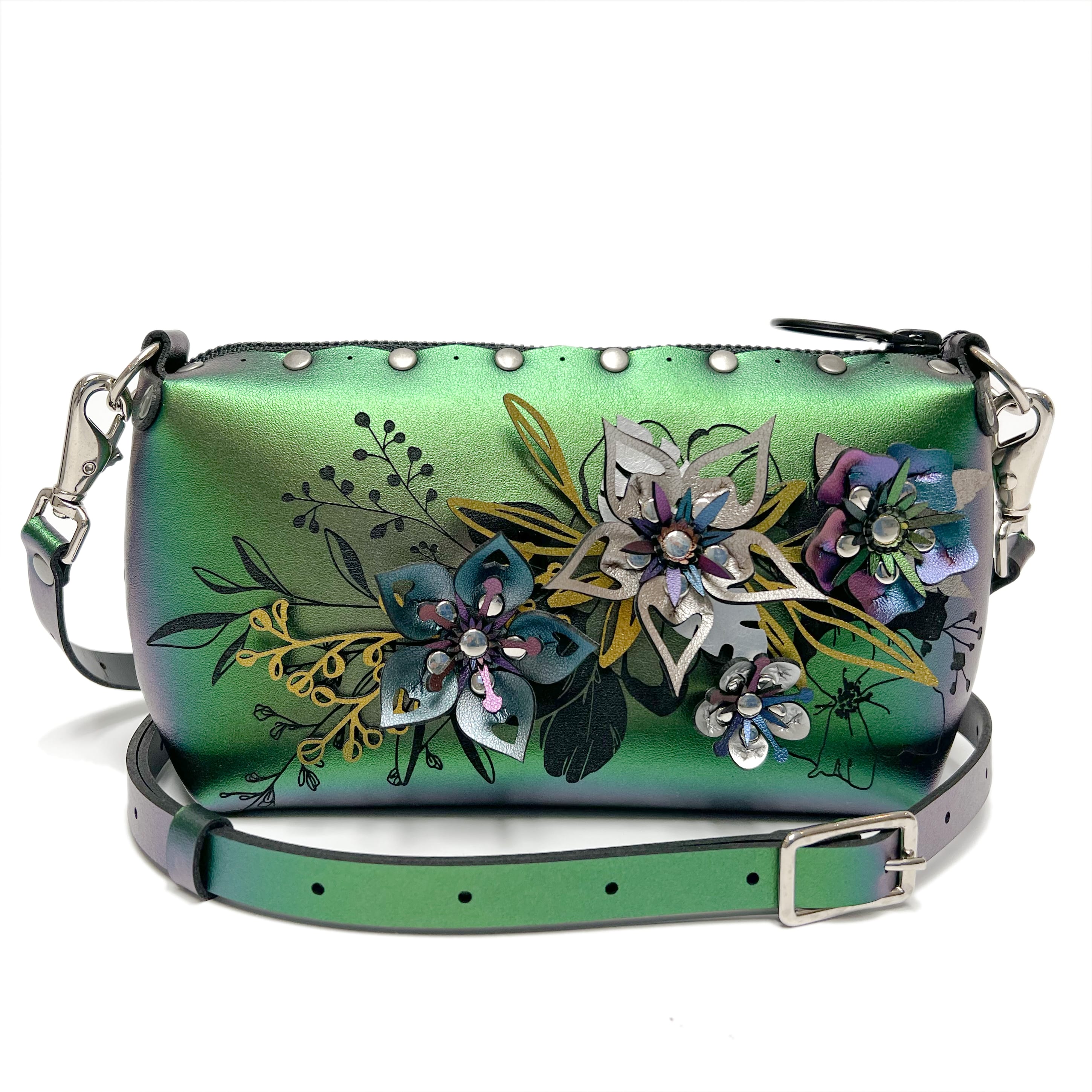 A green purse with many flowers adorn on it.