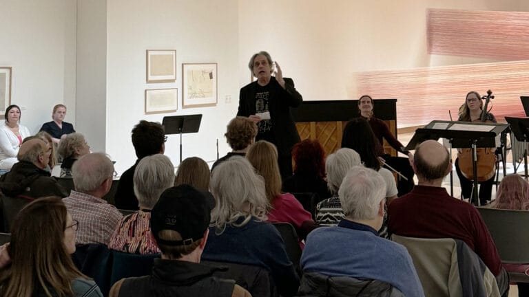 A band conductor addressing an audience.