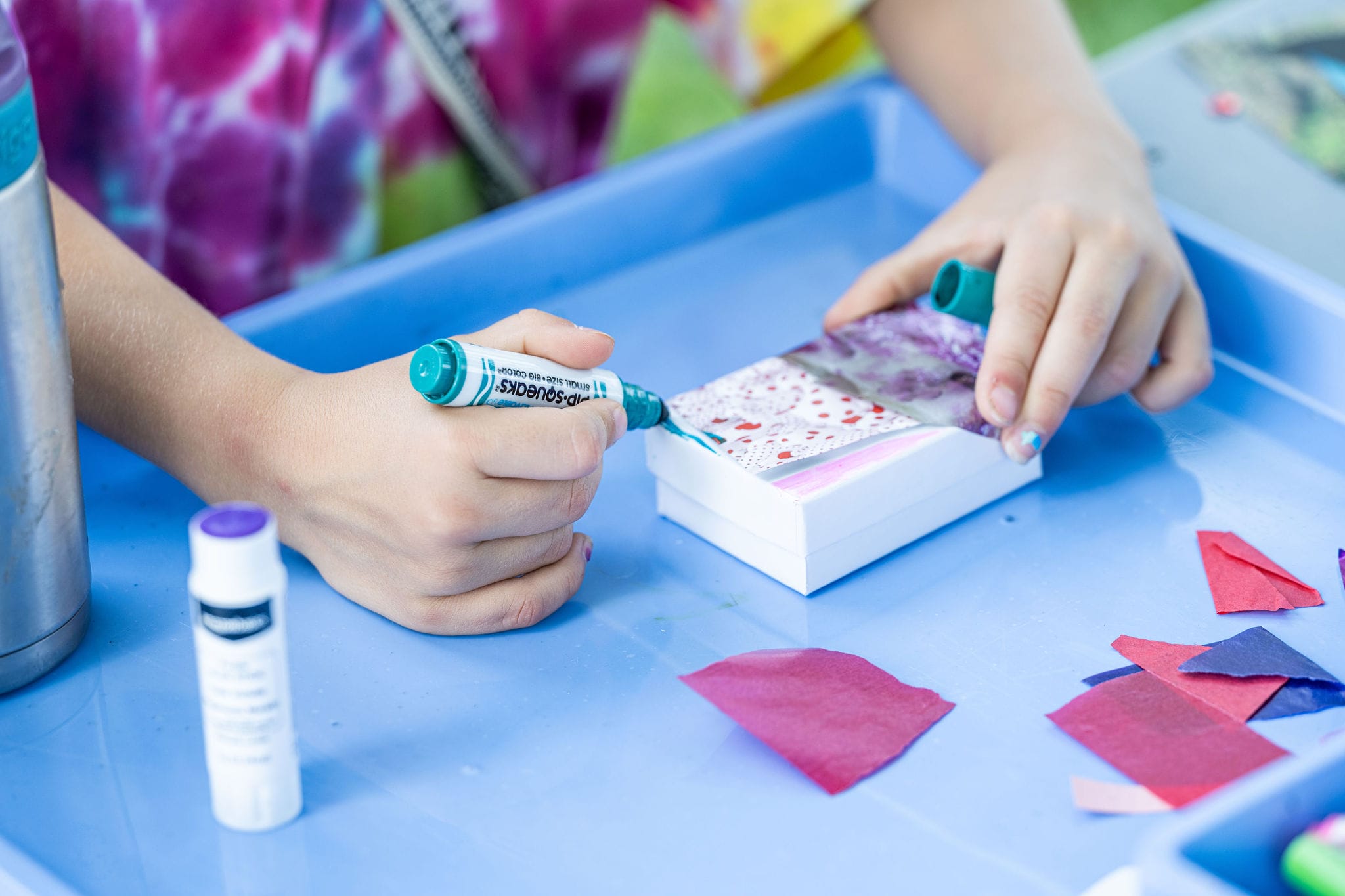 A child drawing on a white block with a marker