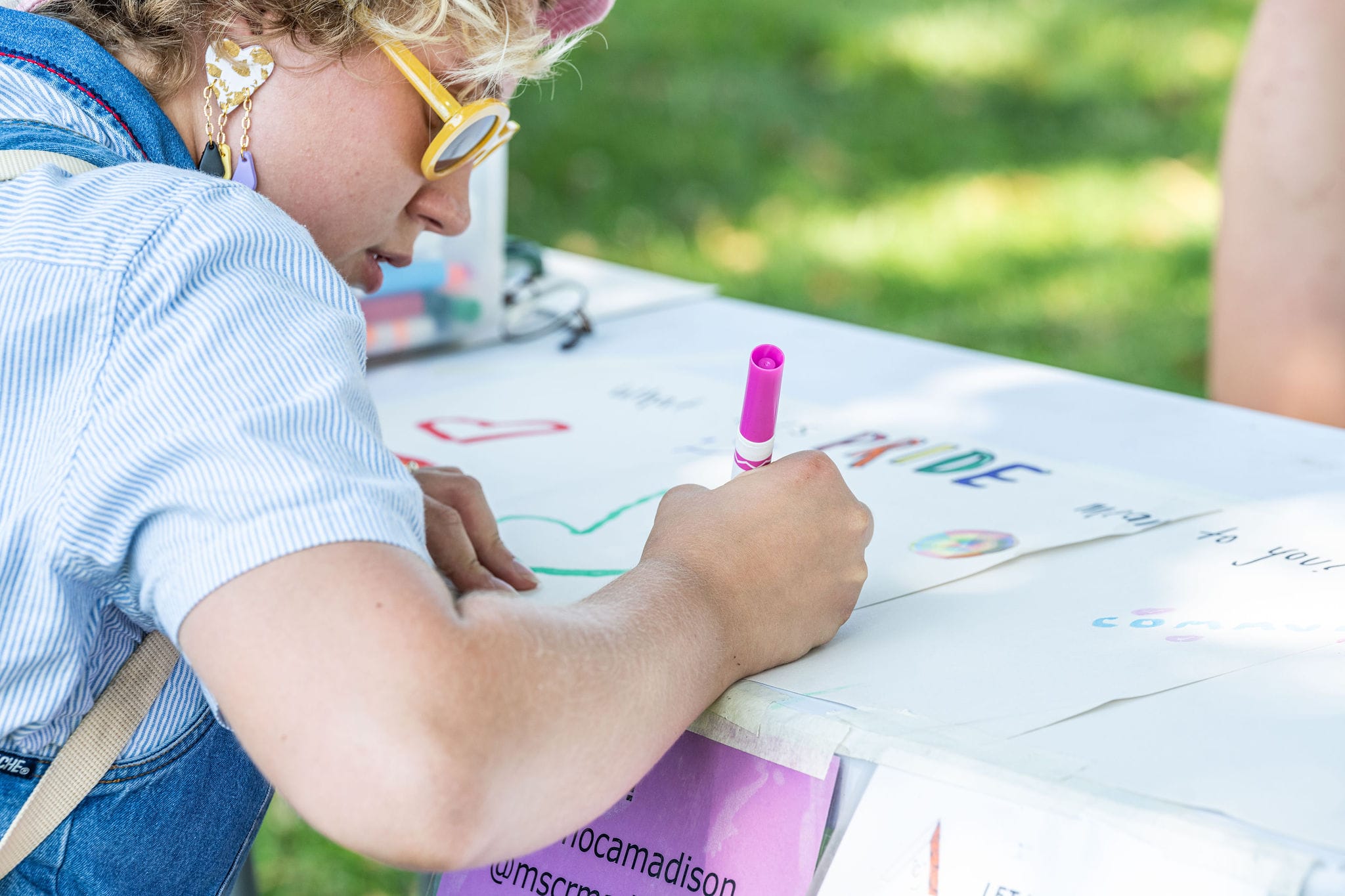 A person drawing with a marker on a white table.